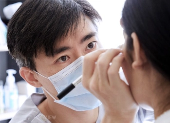 Plastic surgeon performing a preoperative facial design consultation, carefully marking and assessing facial proportions before surgery.
